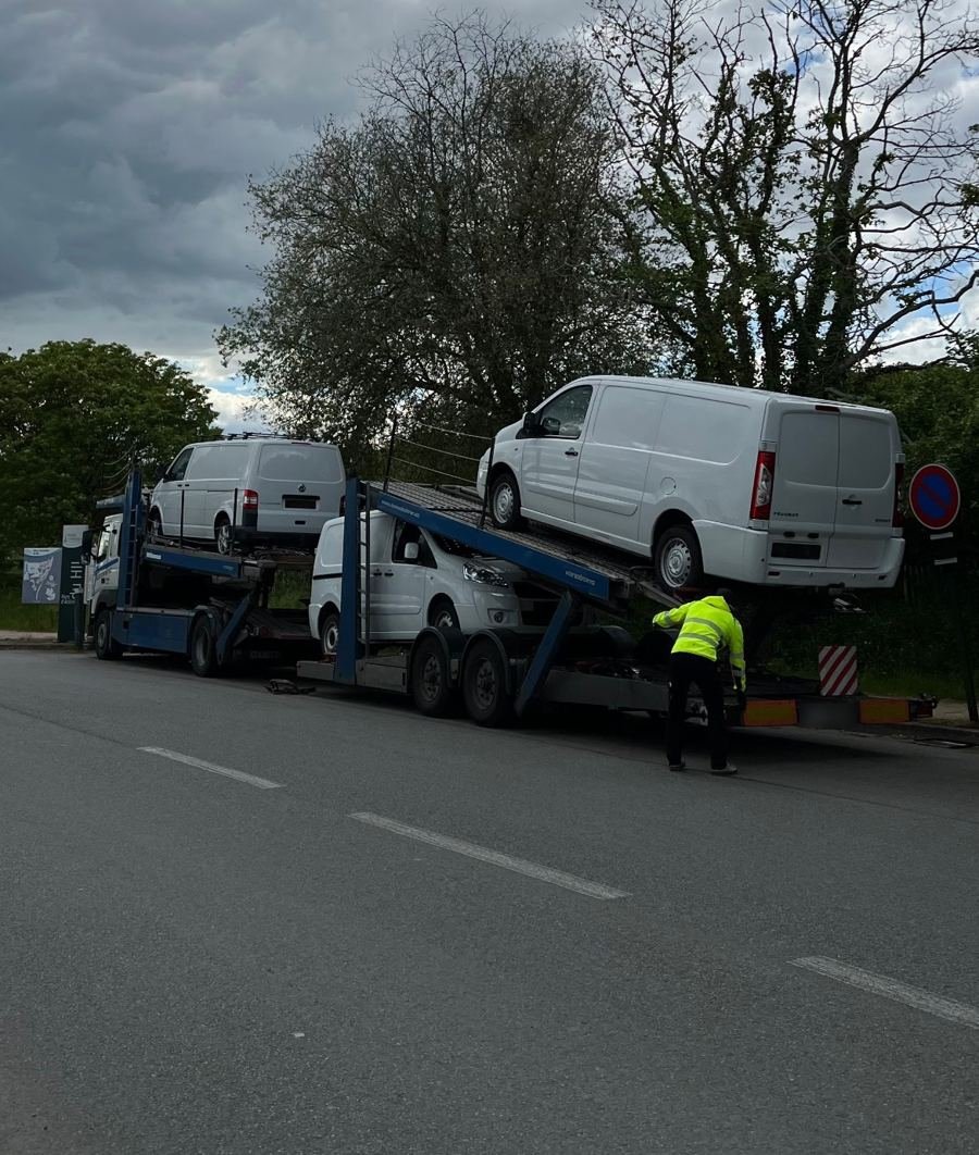 Arrivage de trois utilitaires importés de Suède, déchargés devant le garage BILNCO